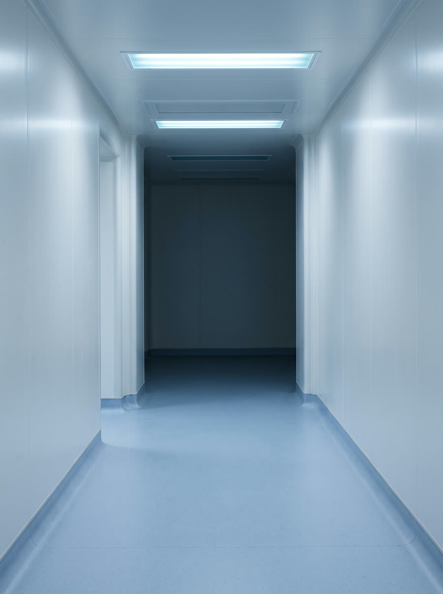 An empty cleanroom corridor finished in continuous hygienic sheet cladding.